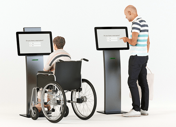 person in wheelchair using kiosk with standing person using kiosk